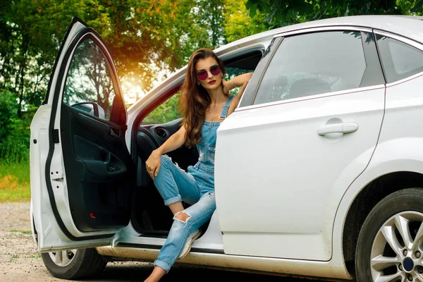 güzel esmer bir arabada otururken poz