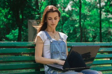 Harika esmer güneşli bir günde bir dizüstü bilgisayar ile parkta portresi