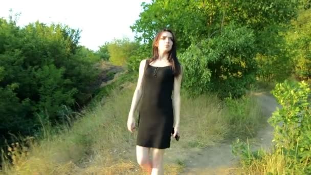 Une belle jeune femme en robe noire marchant dans la rue — Video