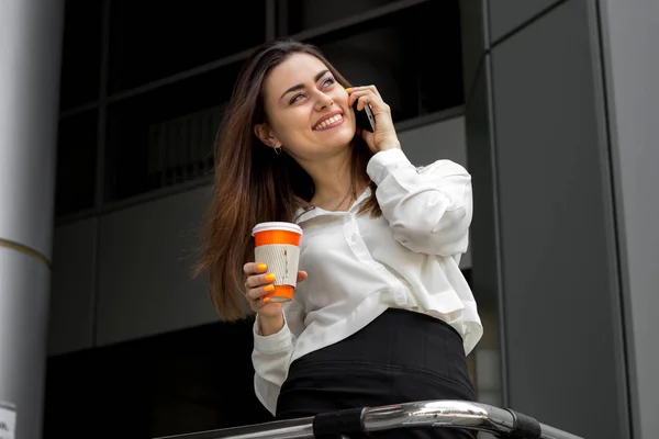 Joyful Office Lady hålla en kaffe i handen och prata i telefon — Stockfoto