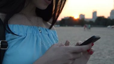 Akşam elinde bir telefon ile genç bir kız portresi