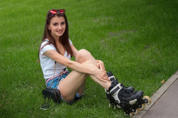 Veselá mladá žena úsměvy na fotoaparát s válečkem na nohy — Stock fotografie