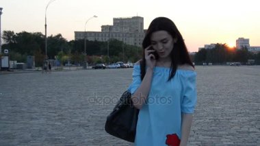 nazik bir elbise güzel genç bayan akşam şehir için gider ve telefonda diyor