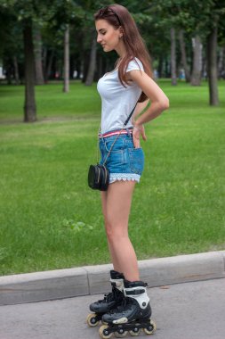 Sıska büyüleyici esmer parkta paten üzerinde sürmek.