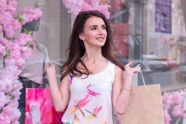 genç esmer kız gülümsüyor elinde alışveriş torbaları ile