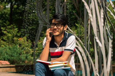 yakışıklı genç adam kitap ve zil tutar