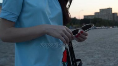 Kırmızı tırnak ile genç kız sokak ve tutan gözlükleri standları