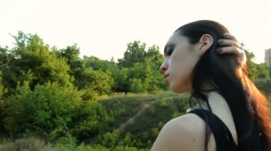 Seksi esmer güzel doğa görünüyor mesafe içine duruyor ve el saç geliştirir