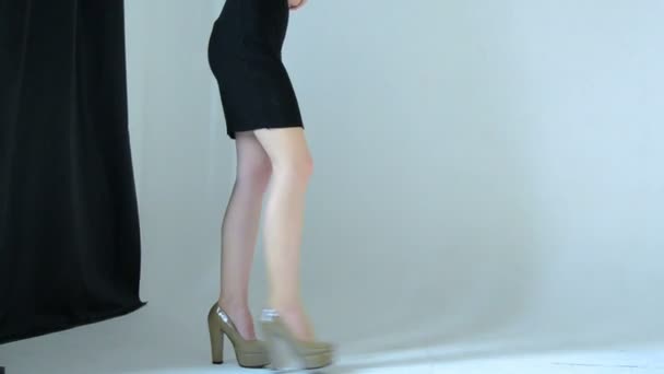Štíhlá dívka v černé šaty a boty na podpatku procházky — Stock video