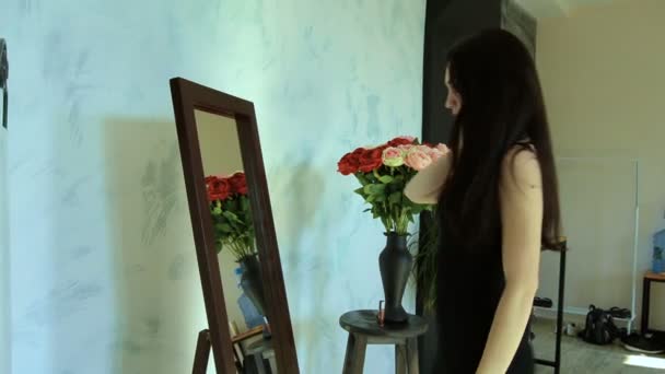 Mooie Sexy brunette in zwarte jurk poseren voor een spiegel — Stockvideo