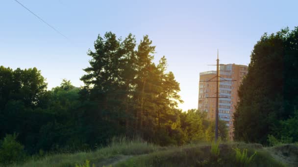 Kväll solstrålar mellan hus och träd — Stockvideo