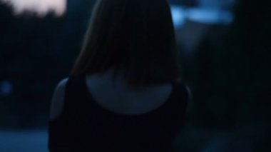 kısa saçlı çekici gülümseyen kadın karanlıkta şehir etrafında yürür