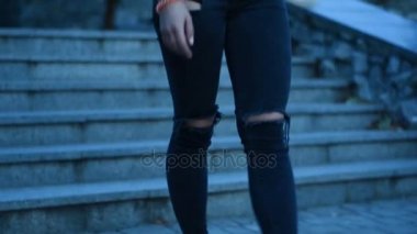 kız siyah t-shirt ve kot merdivenlerden sokağa iner.