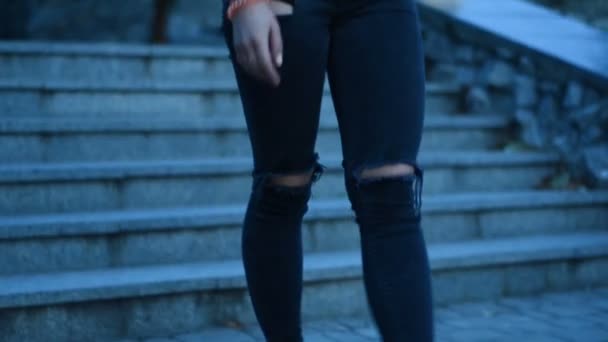 Girl in a black t-shirt and jeans descends the stairs on the street — Stock Video