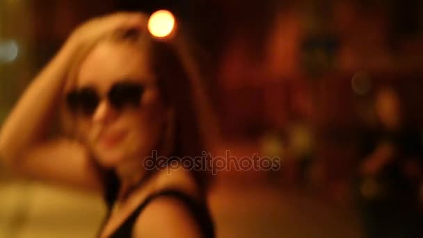 Çekici Bayan bardaklarda geceleri sokak görüntüsü üzerinde fotoğraf makinesine gider — Stok video