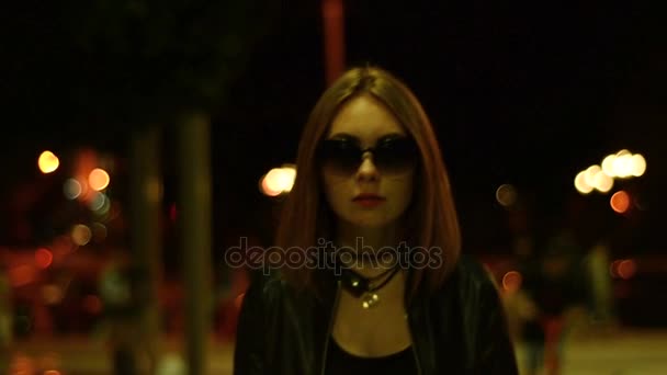 Aika vakava Lady lasit menee kaupunkiin yöllä katsoo kameraan — kuvapankkivideo