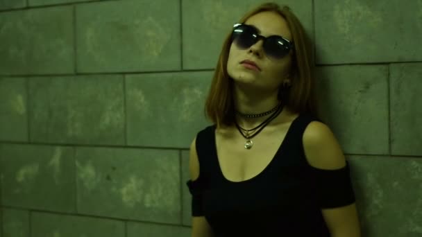 Молодая сексуальная стильная леди в очках, стоящая у стены — стоковое видео