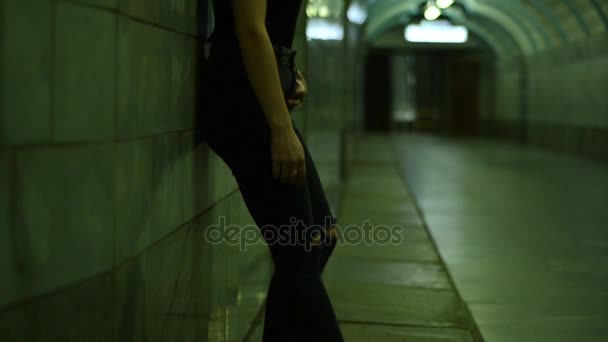 Όμορφο κορίτσι μόδας σε πάνινα παπούτσια και γυαλιά που στέκεται για την υπόγεια διάβαση — Αρχείο Βίντεο