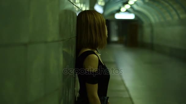 Senhora elegante em óculos de sol posando para a câmera na passagem subterrânea — Vídeo de Stock