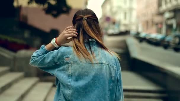 Σέξι νεαρή κοπέλα με κόκκινα χείλη περπατάει στο δρόμο και γυρίζει στην κάμερα — Αρχείο Βίντεο
