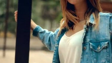 Kırmızı dudaklar ile genç sarışın bir ayağı duruyor