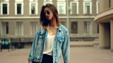 Genç sarışın seksi kırmızı dudaklar ile yavaş yavaş gülümser ve arka kamera üzerinde yürür