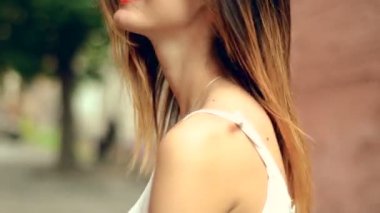 Kırmızı dudaklar ve güneş gözlüğü ile seksi genç sarışın sokakta yürüyor