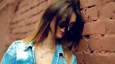 kırmızı güneş gözlüklü şirin genç sarışın stans bir tuğla duvar dudakları.