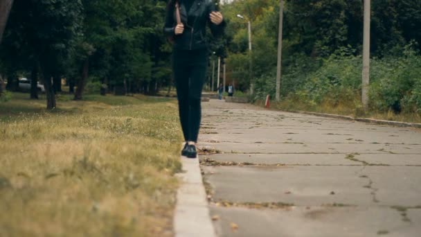 Jeune femme en noir marche sur la frontière — Video