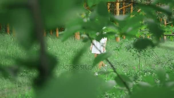Latin kız beyaz elbiseli bir patika bir ormanda yürür — Stok video