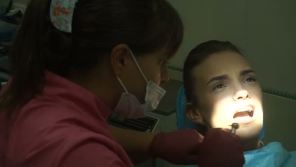 Молодая девушка лечит зубы — стоковое видео