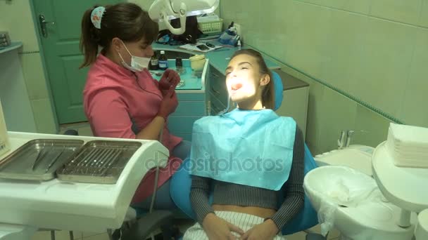 Очаровательная молодая девушка лечит зубы — стоковое видео