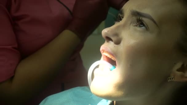Jovem mulher bonito trata seus dentes — Vídeo de Stock