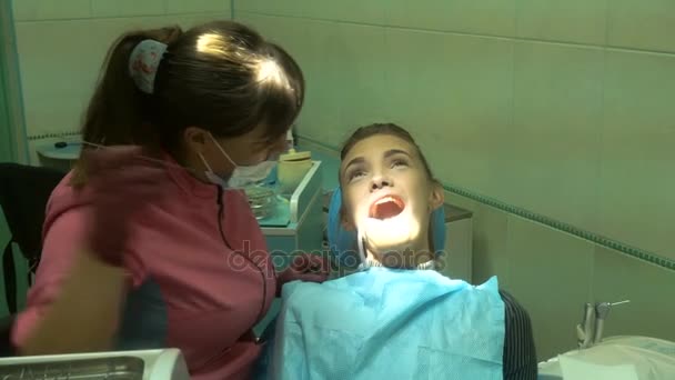 Mulher encantadora no dentista trata seus dentes — Vídeo de Stock