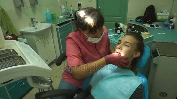Schöne junge Mädchen behandelt ihre Zähne — Stockvideo