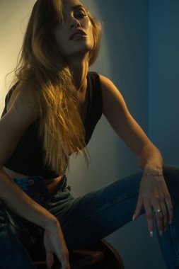 Güzel genç sarışın kız güzel makyaj ile oturur ve kameraya benziyor