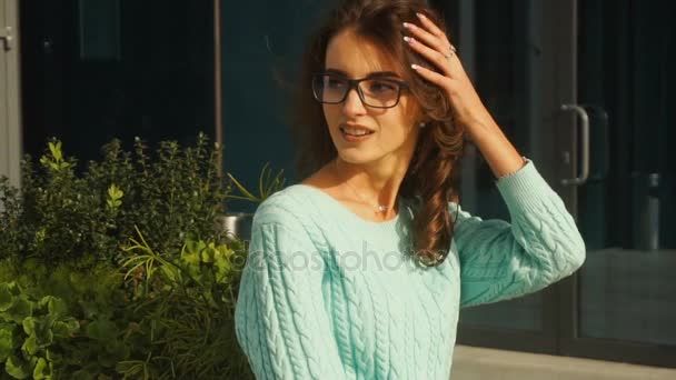 Jeune belle femme en lunettes de soleil sourit et tourne son visage de côté — Video