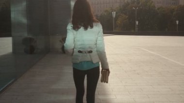 zeki genç öğrenci Kız bardaklarda açık havada eller ve gülümsüyor kitap ile yürür.