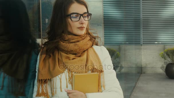 Young attractive student in glasses with books in hands — Stock Video