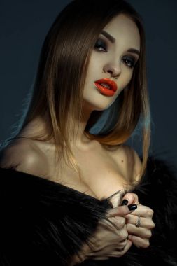 Kameraya bakarak kürk paltolu kırmızı dudaklar ile genç çekici Bayan