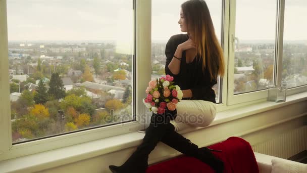 Vacker dam sitter på fönsterbrädan och sniffa blommor — Stockvideo