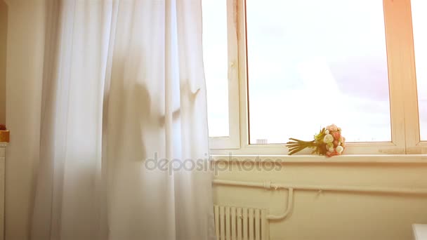 Cute girl stands behind the curtain at the window comes and looking into the camera — Stock Video