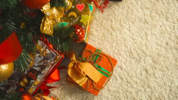 Mujer pone bajo el regalo del árbol de Navidad en el paquete de oro — Vídeos de Stock
