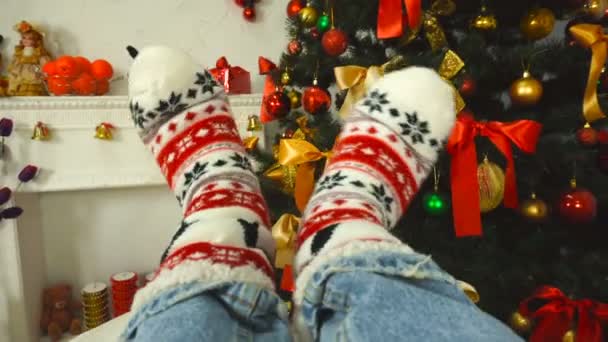 Chica en un calcetín con adorno cerca del árbol de Navidad — Vídeos de Stock