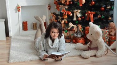 Noel ağacı ve bir kitap okuma genç şirin esmer yalan halı üzerinde yakın