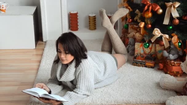 Beautiful Young Girl Lying Floor Christmas Tree Looks Notepad — Stock Video