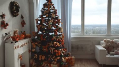 sıcak kazaklı genç esmer güzel bir Noel ağacı yakınındaki bir pencereye yürür ve sokakta evde görünüyor