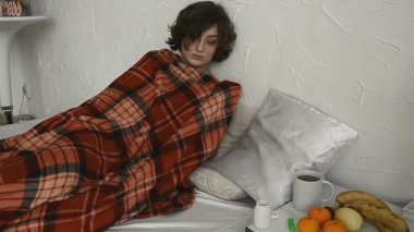 hasta bir kadına bir battaniyenin altında yatıyor ve evde sıcaklık ölçümleri vücut