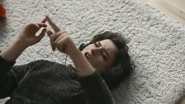 여자는 바닥에 집에서 헤드폰으로 음악을 — 비디오