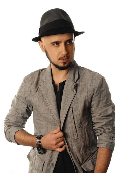 Молодой гламурный мужчина в шляпе и куртке смотрит в сторону — стоковое фото